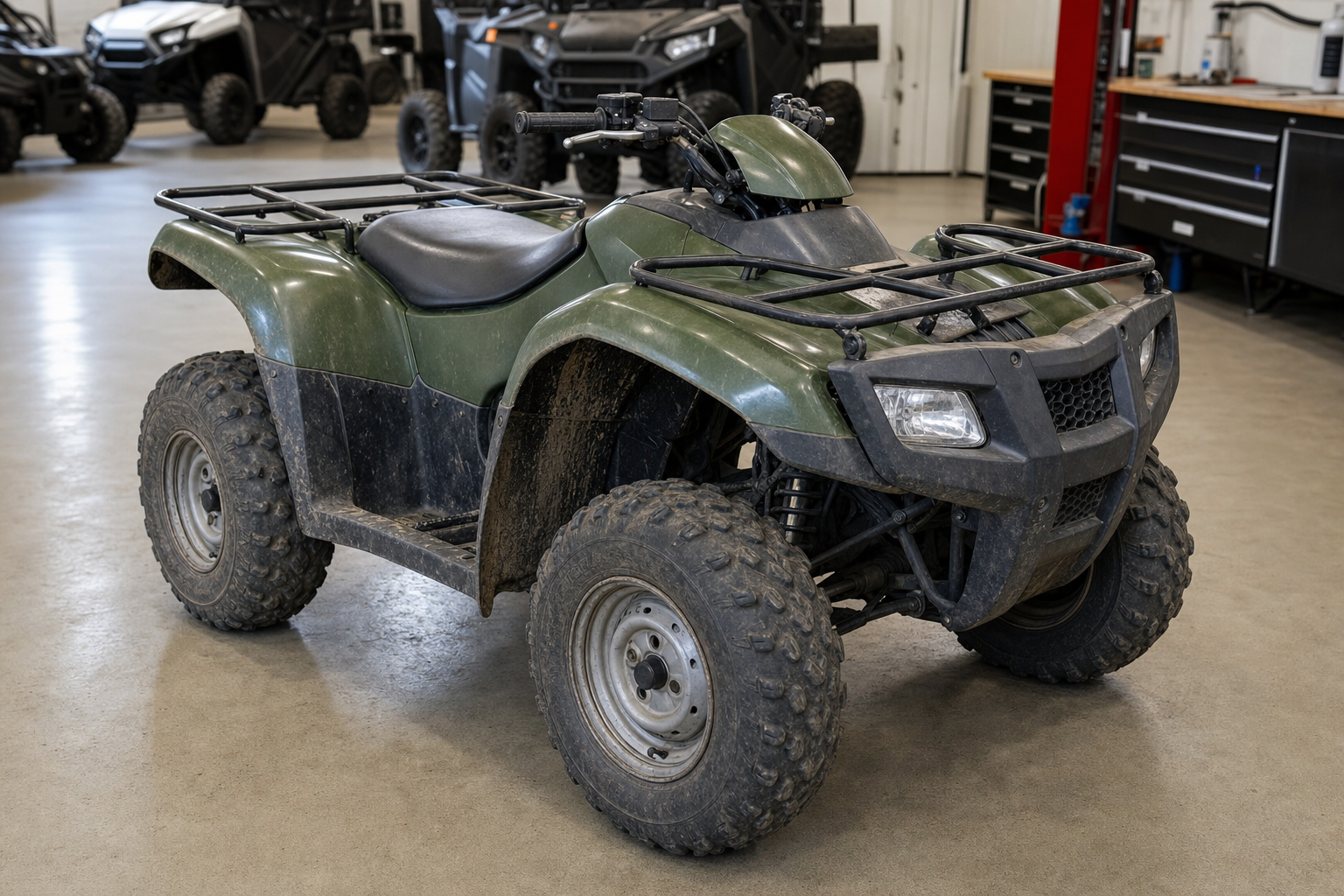 A used utility ATV quad parked on a clean dealership service shop floor in soft overhead lighting showing honest light trail wear